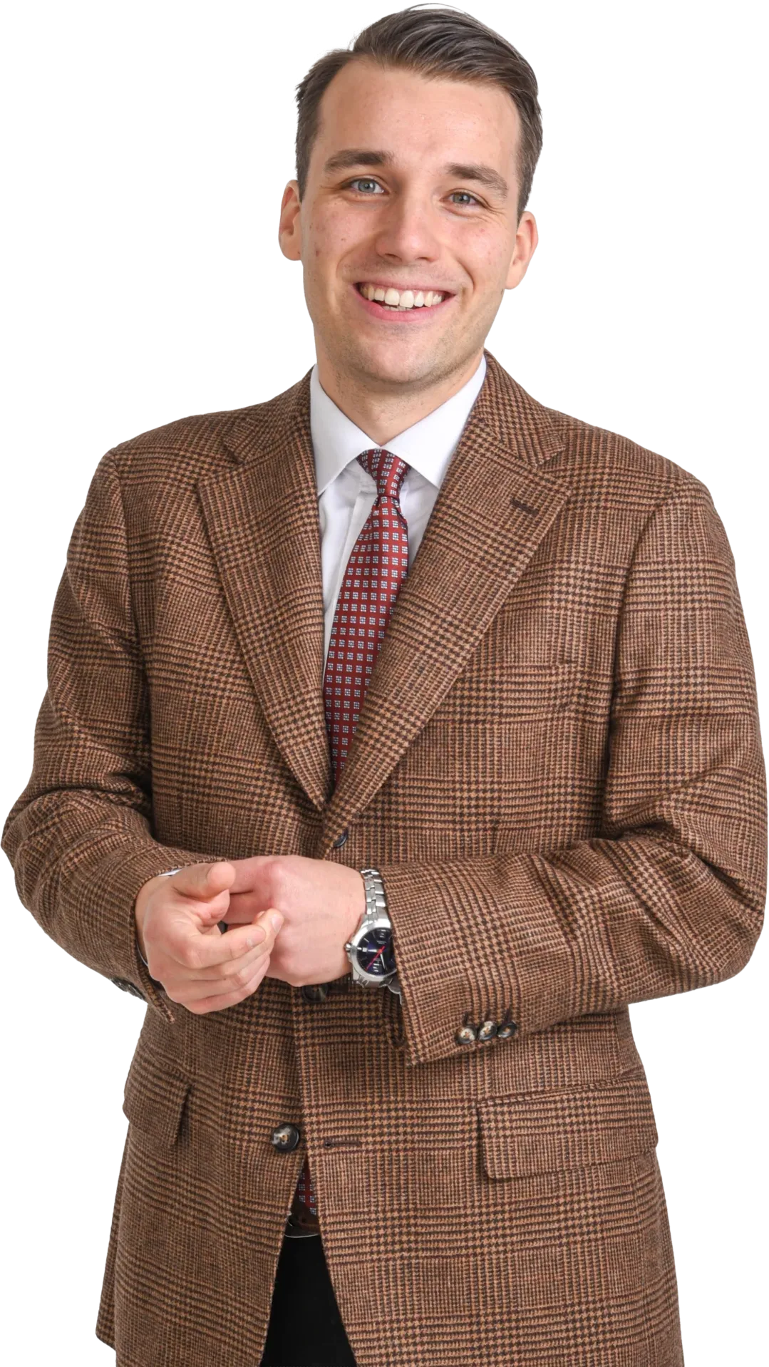 Hymyilevä mies ruskeassa takissa, valkoisessa paidassa ja punaisessa solmiossa mustalla taustalla.